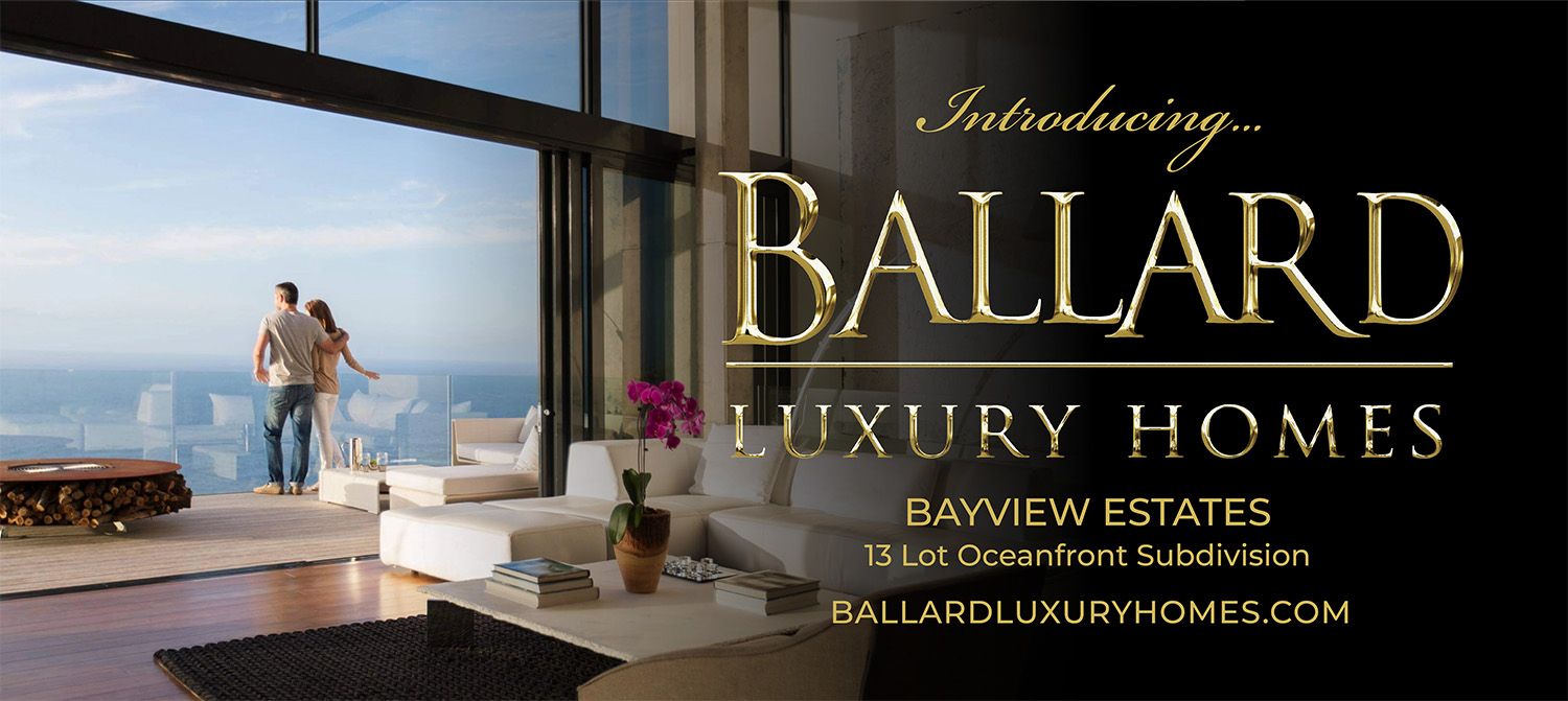 Two people on the beach with arms outstretched looking at the sunset.